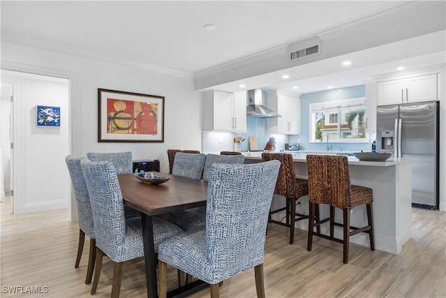 dining room featuring crown molding and light wood-type flooring