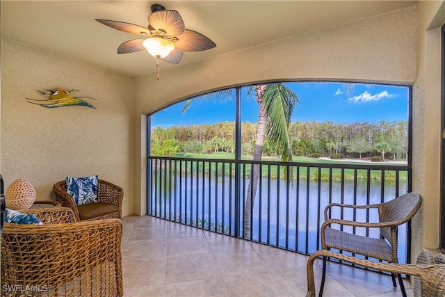 sunroom / solarium with a water view and ceiling fan