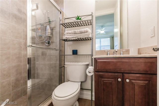 bathroom with a shower with door, vanity, and toilet