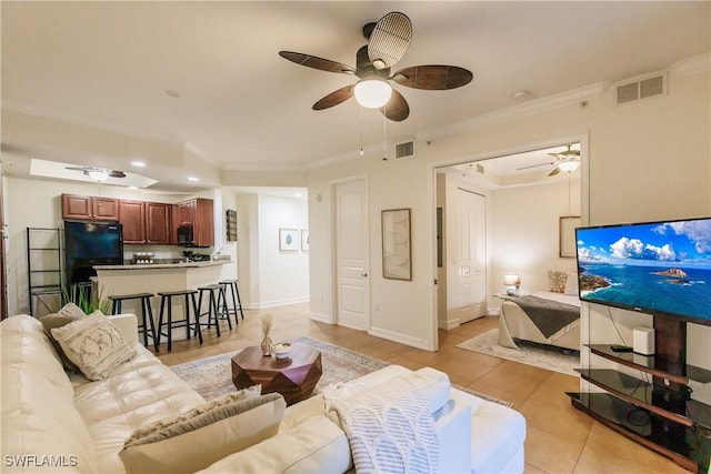 living room with ceiling fan, ornamental molding, and light tile patterned flooring