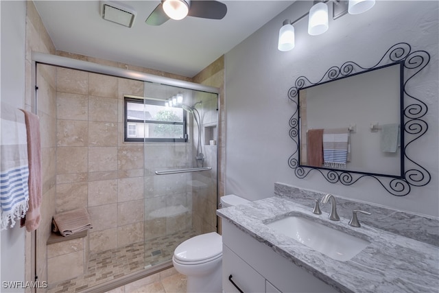 bathroom with vanity, tile patterned flooring, ceiling fan, toilet, and a shower with shower door