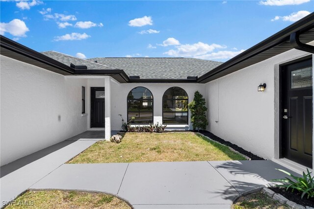 doorway to property with a lawn