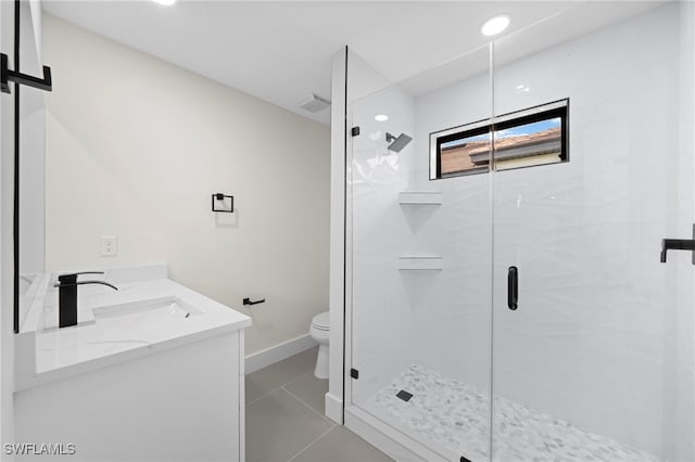 bathroom with tile patterned floors, vanity, an enclosed shower, and toilet