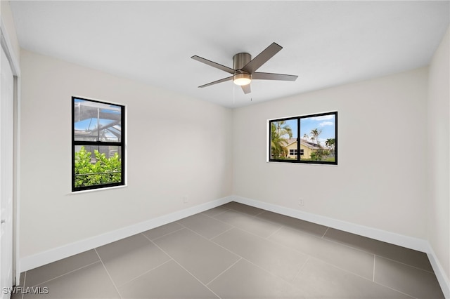 tiled empty room featuring ceiling fan and plenty of natural light