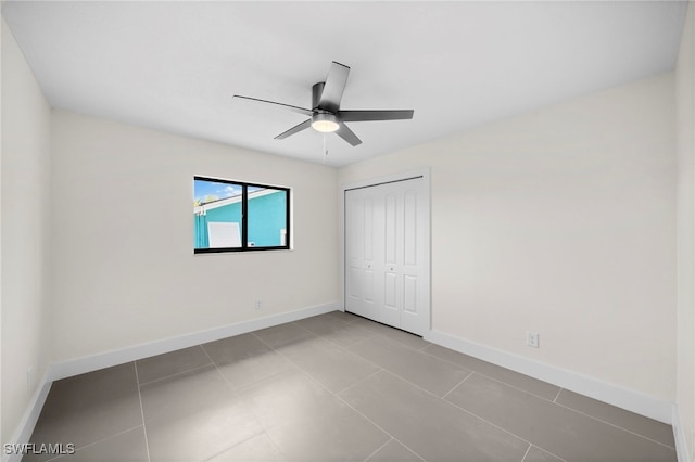 unfurnished bedroom featuring light tile patterned floors, a closet, and ceiling fan