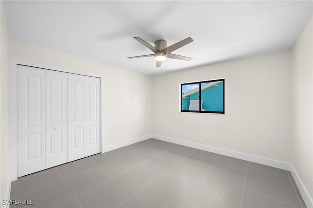 unfurnished bedroom featuring ceiling fan, a closet, and tile patterned flooring