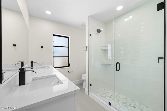 bathroom featuring vanity, a shower with shower door, and toilet