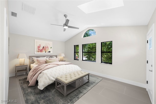 bedroom featuring tile patterned floors, ceiling fan, and lofted ceiling with skylight