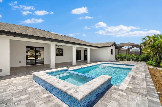 view of swimming pool with a lanai, an in ground hot tub, ceiling fan, and a patio