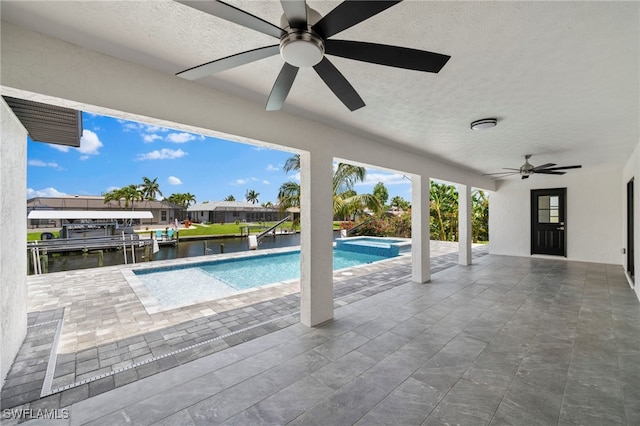 view of swimming pool with ceiling fan, a patio area, and a water view