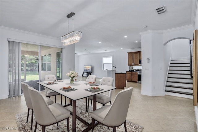 tiled dining room featuring a chandelier, ornamental molding, a healthy amount of sunlight, and sink