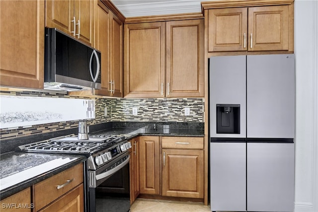 kitchen featuring appliances with stainless steel finishes, backsplash, light tile patterned floors, and dark stone counters