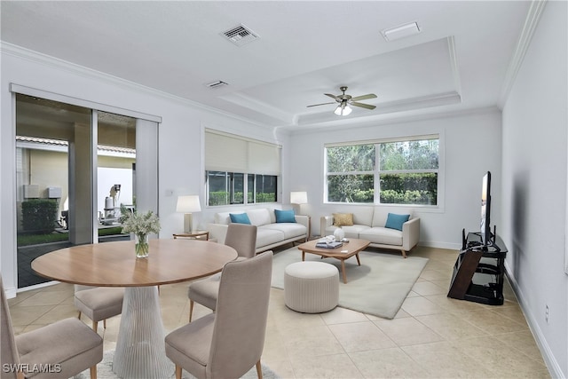 living room featuring light tile patterned floors, a raised ceiling, ceiling fan, and ornamental molding