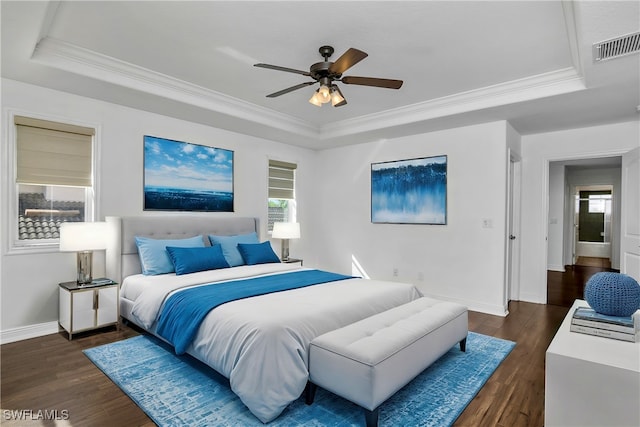 bedroom featuring ornamental molding, dark hardwood / wood-style floors, ceiling fan, and a tray ceiling