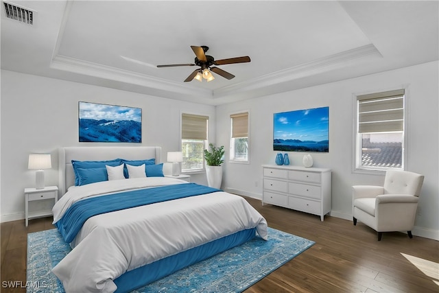 bedroom featuring a tray ceiling, multiple windows, and ceiling fan