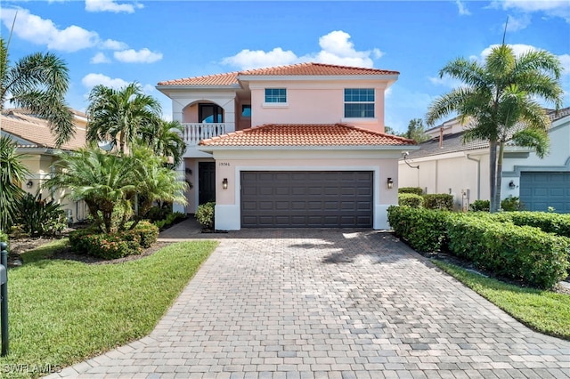 mediterranean / spanish house with a balcony, a front yard, and a garage