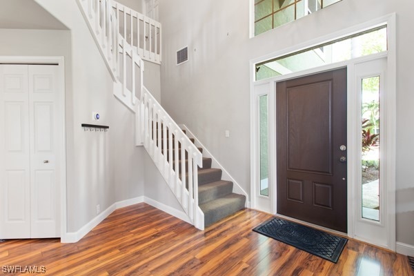 foyer entrance featuring wood-type flooring and a high ceiling