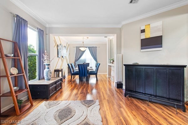 sitting room with crown molding and light hardwood / wood-style floors