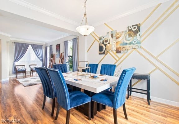 dining area featuring ornamental molding and hardwood / wood-style flooring