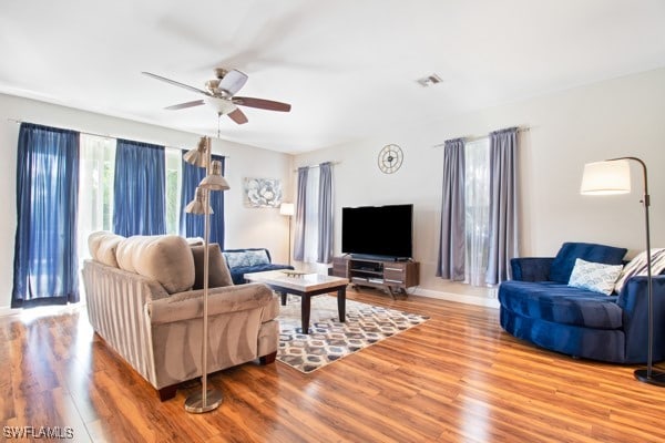 living room featuring hardwood / wood-style floors and ceiling fan