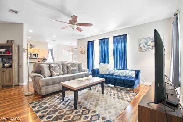 living room with wood-type flooring and ceiling fan