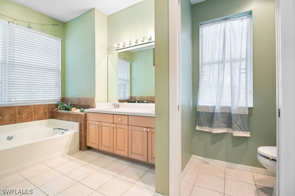 bathroom featuring a washtub, vanity, tile patterned floors, and toilet