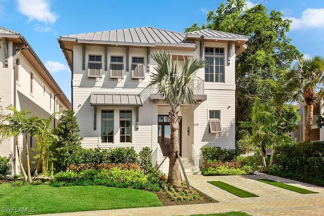 view of front of property featuring a standing seam roof, metal roof, and a front lawn