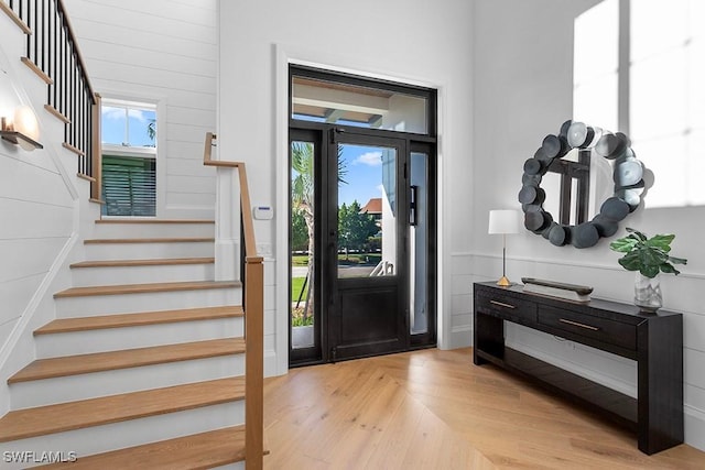entryway featuring stairway, a wainscoted wall, and wood finished floors