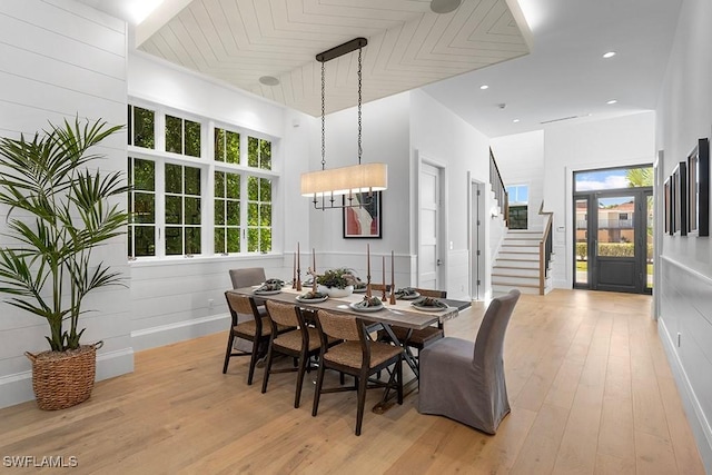 dining area with light wood-style flooring and stairway