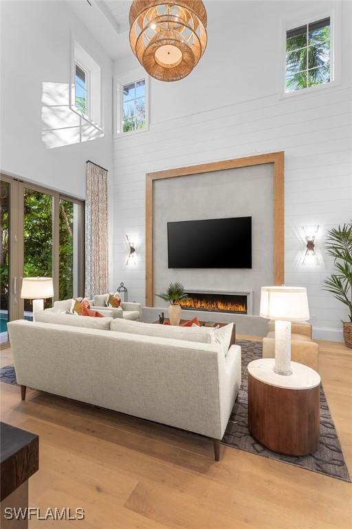 living room featuring a high ceiling, wood finished floors, and wood walls