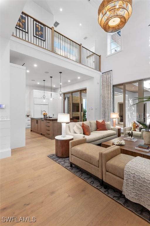 living room featuring a high ceiling and light wood-style flooring