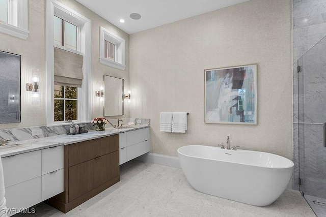 full bath featuring vanity, a freestanding bath, a stall shower, and baseboards