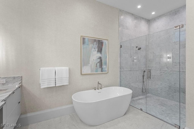 bathroom with a stall shower, a freestanding bath, vanity, baseboards, and recessed lighting