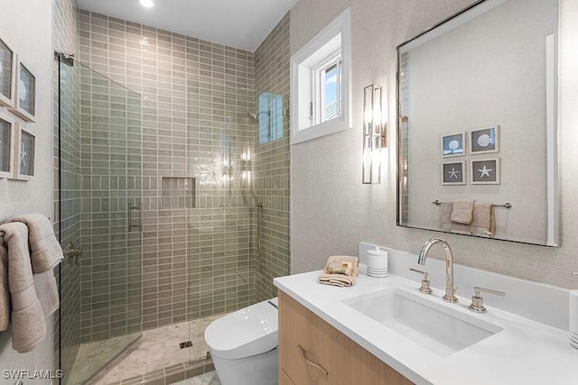 bathroom with toilet, a stall shower, and vanity