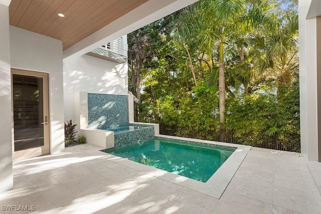 view of swimming pool with a patio and a pool with connected hot tub