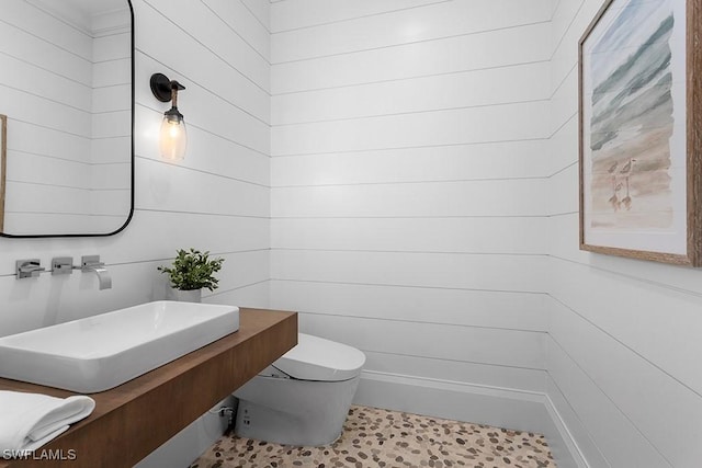 half bath featuring toilet and a sink
