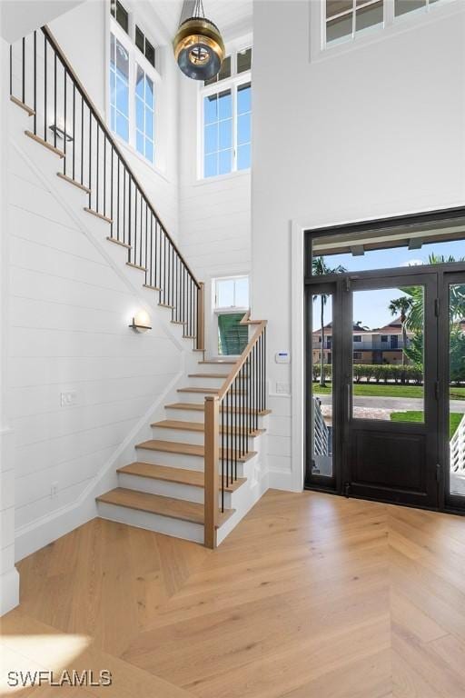entrance foyer featuring a high ceiling, stairway, and healthy amount of natural light