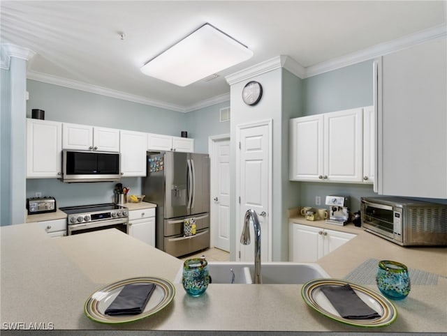 kitchen featuring white cabinets, appliances with stainless steel finishes, sink, and crown molding