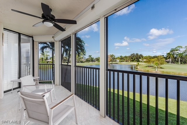 sunroom featuring a water view and ceiling fan