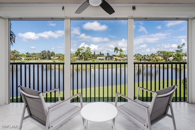 sunroom featuring a water view and ceiling fan