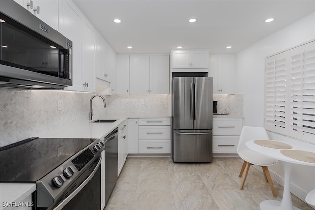 kitchen with tasteful backsplash, white cabinets, sink, and stainless steel appliances