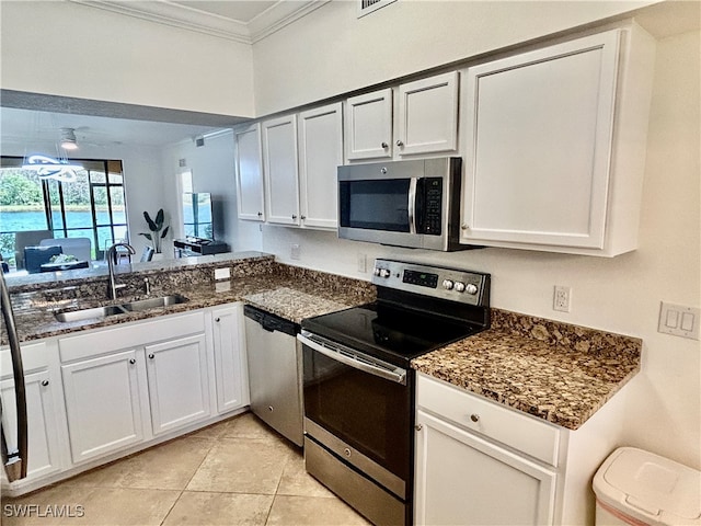 kitchen with stainless steel appliances, white cabinets, sink, ornamental molding, and light tile patterned flooring