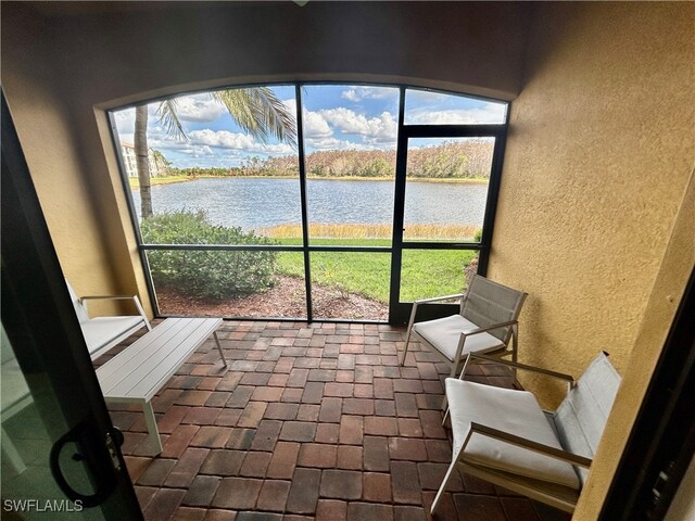 unfurnished sunroom featuring plenty of natural light and a water view