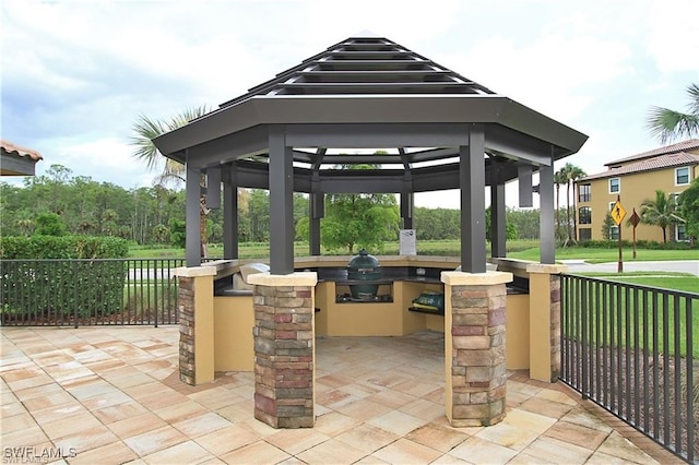 view of patio / terrace featuring an outdoor kitchen, area for grilling, a bar, and a gazebo