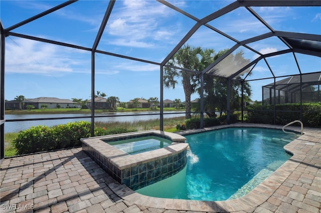 view of pool with a patio area, glass enclosure, a water view, and an in ground hot tub