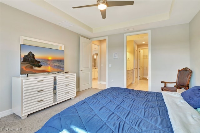 carpeted bedroom with connected bathroom, ceiling fan, and a raised ceiling