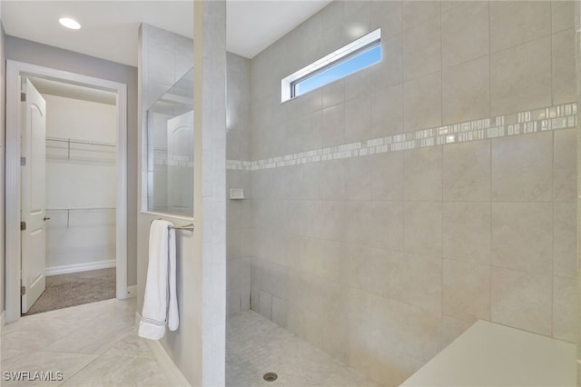 bathroom with tiled shower and tile patterned floors