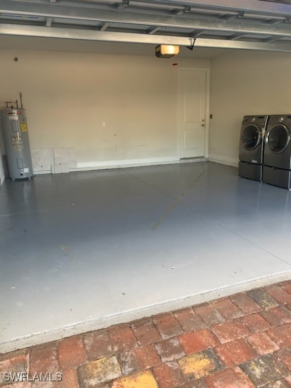 garage with electric water heater and washer and clothes dryer