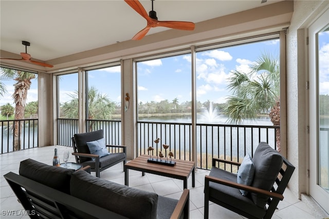 sunroom / solarium with a water view and ceiling fan