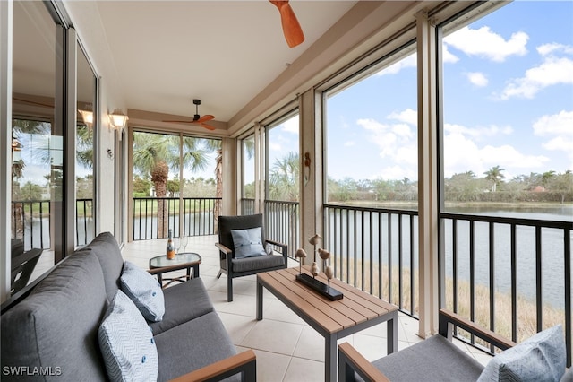 sunroom featuring ceiling fan and a water view